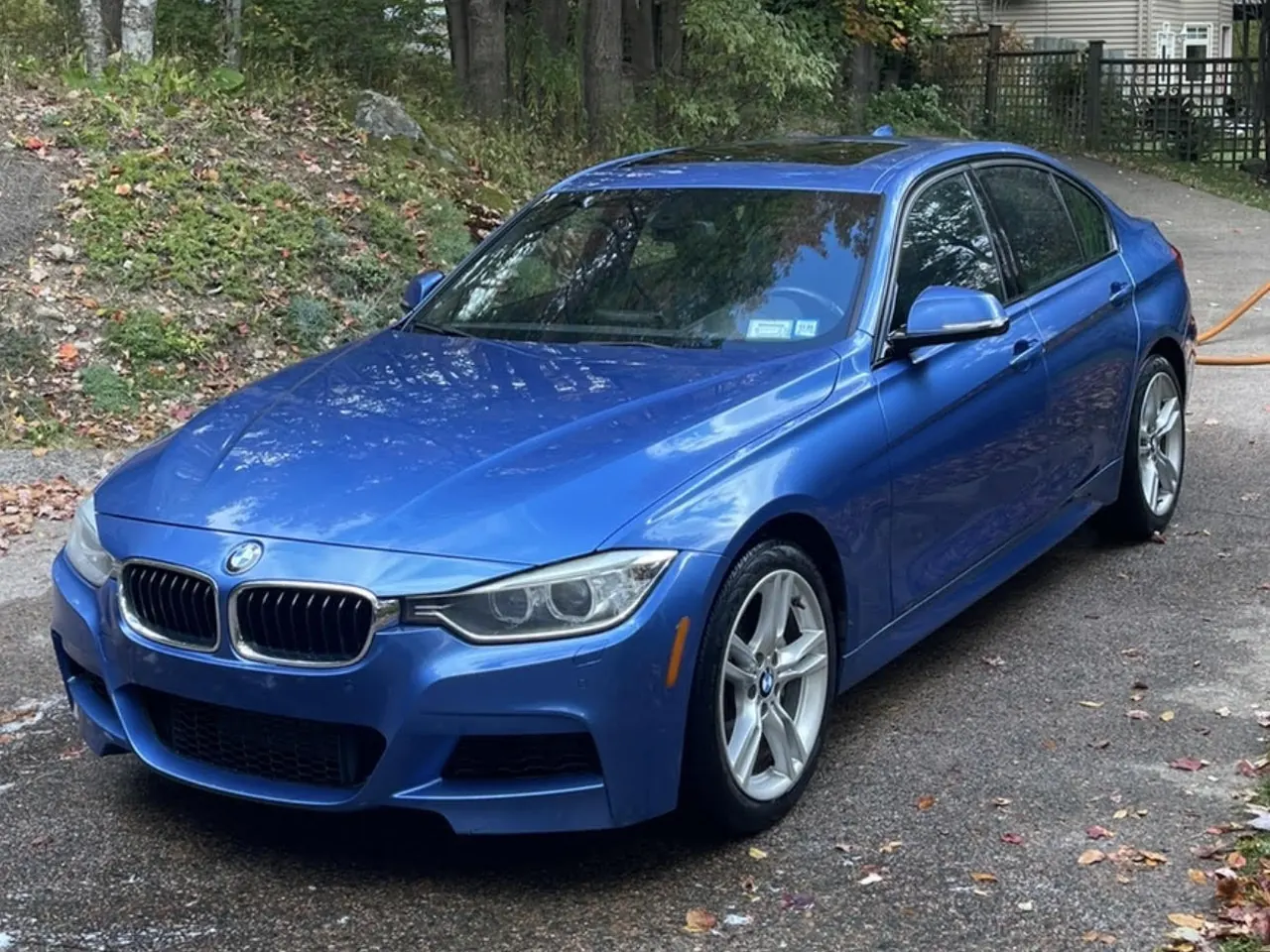 A blue BMW 3 Series on a driveway