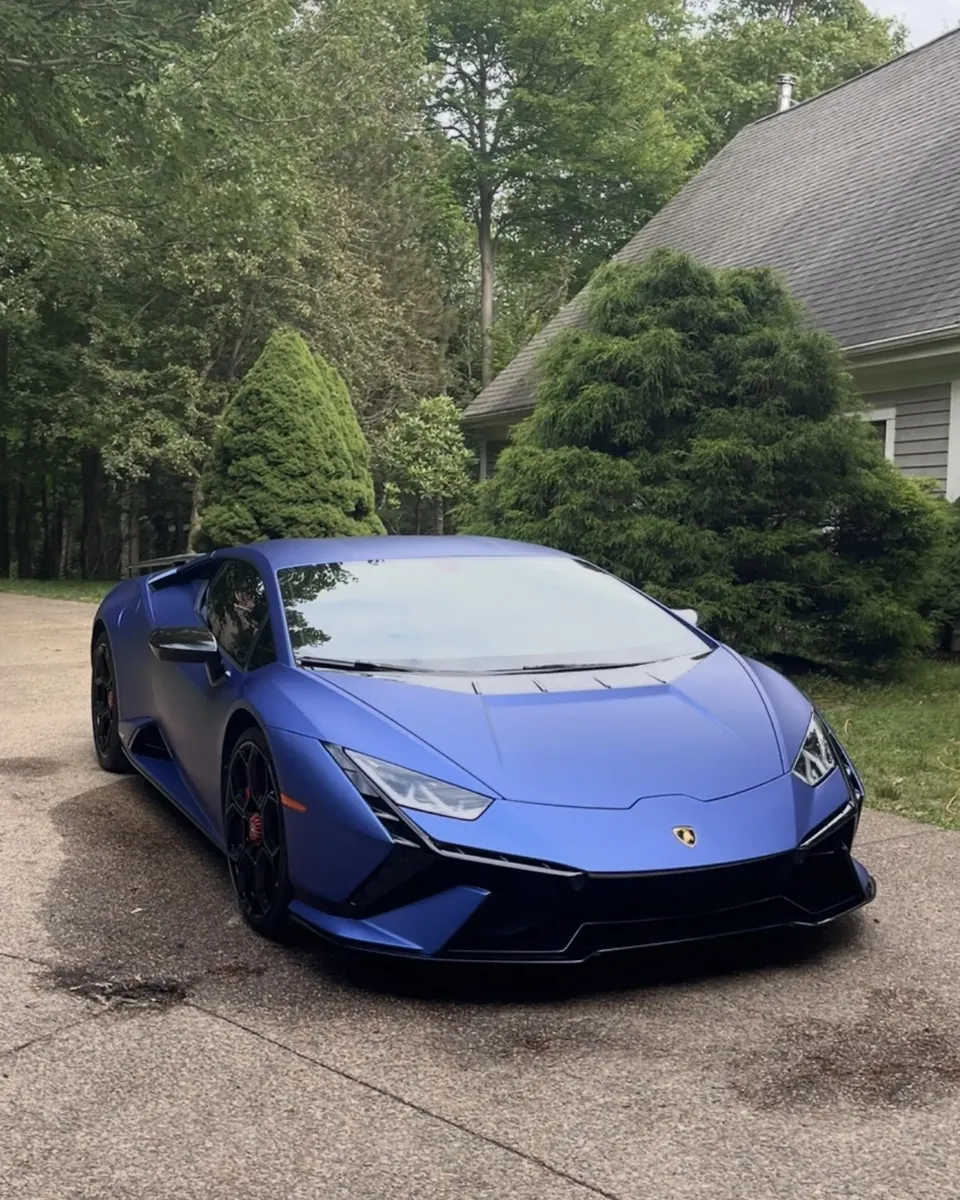 A matte blue Lamborghini Huracán on a driveway