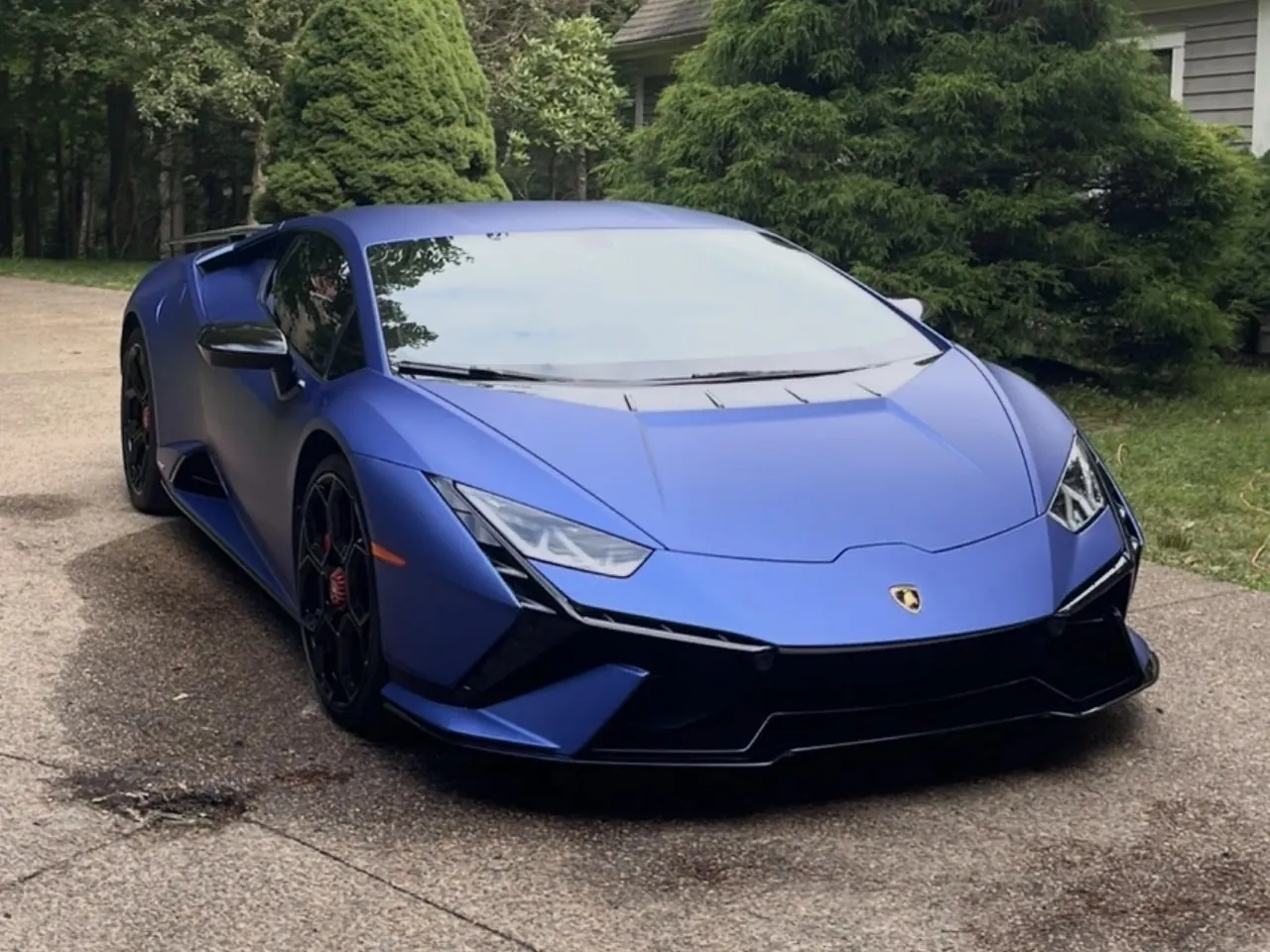 A matte blue Lamborghini Huracán on a driveway