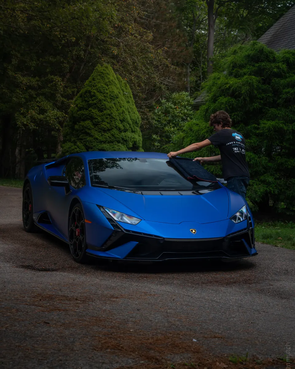 Jake drying a blue Lamborghini Huracán with a towel